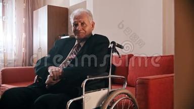 <strong>年迈</strong>的祖父-快乐的祖父坐在轮椅上看着摄像机
